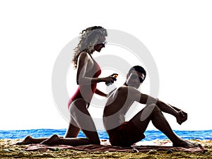 Couple applying sun protection on the beach