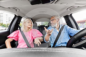 Couple arguing inside a car on a daytime drive