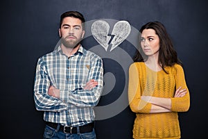 Couple after argument standing separately over blackboard background