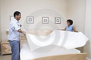 Couple Arranging Bedsheet