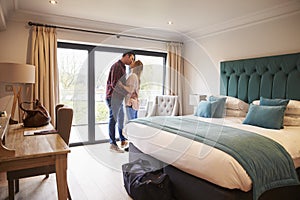 Couple Arriving In Hotel Room On Vacation photo