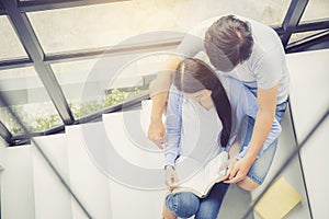 Couple asian handsome man and beautiful woman reading book and smile at home.