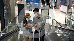 Couple Asian people walking in airport terminal waiting for  flight boarding.