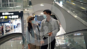 Couple Asian people walking in airport terminal waiting for  flight boarding.