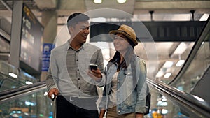 Couple Asian people walking in airport terminal waiting for  flight boarding.