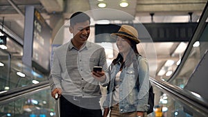 Couple Asian people walking in airport terminal waiting for  flight boarding.