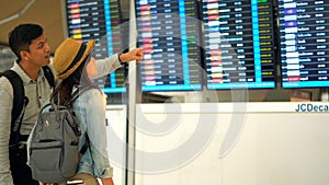 Couple Asian people walking in airport terminal waiting for  flight boarding.