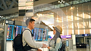 Couple Asian people walking in airport terminal waiting for  flight boarding.