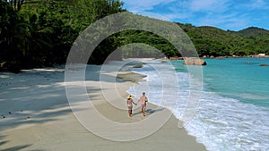 Couple of Asian women and Caucasian men on the beach of Anse Lazio Praslin island Seychelles,