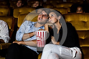 A couple and audience watch a movie in theater