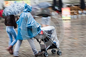 Couple with baby buggy at heavy rain