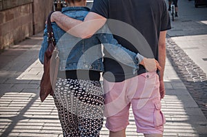 couple back entwined walking in the street