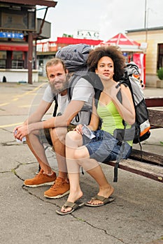 A couple of backpacker tourists sitting on a bench
