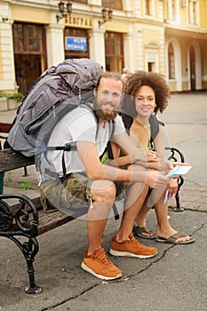 A couple of backpacker tourists sitting on a bench