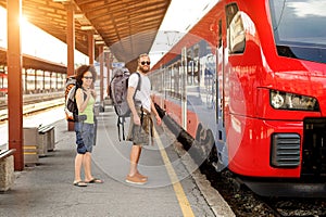 A couple of backpacker tourists waiting to board a train