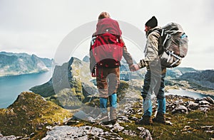 Couple backpackers holding hands enjoying mountains