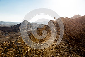 Couple backpackers walking ascending mountain ridge desert trai