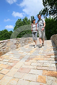 Couple of backpackers walking on bridge