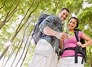 Couple in backpacks looking at compass