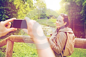 Couple with backpacks taking picture by smartphone