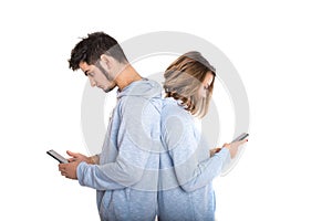 Couple backwards with their mobile phones isolated on white background