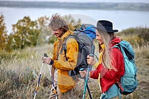 couple with bag pack on back holding hiking pole during hiking jurney.