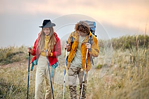 couple with bag pack on back holding trekking pole during hiking jurney.