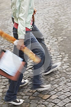 Couple With Baguette And Bags On Cobbled Street