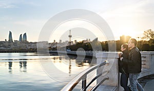 Couple in Baku at sunset looking at the sea. People on a holiday getaway. Happy man and woman on a date. Travel and tourism.