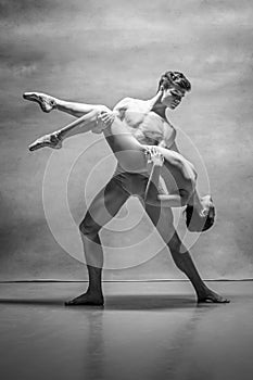 Couple of ballet dancers posing over gray background