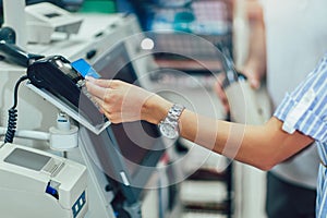 Couple with bank card buying food at grocery store or supermarket self-checkout