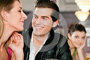 Couple in bar drinking beer flirting