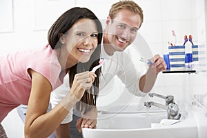 Couple In Bathroom Brushing Teeth photo