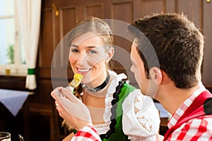 Couple in Bavarian Tracht eating in restaurant