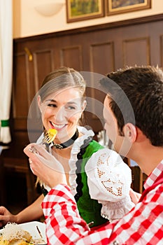 Couple in Bavarian Tracht eating in restaurant