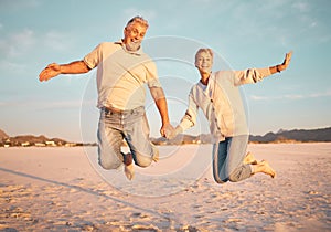 Couple, beach and active seniors hold hands while jumping in sand, happy and excited at sunset. Love, family and freedom
