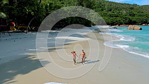 Couple on the beach of Anse Lazio Praslin island Seychelles on a sunny morning.