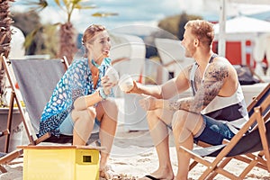 Couple on beach having coconut water