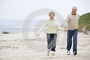 Couple at the beach holding hands and smiling