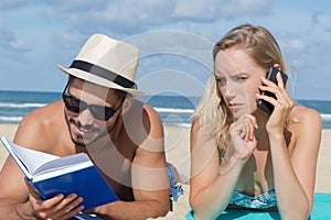 Couple on beach with mobile phones