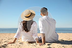 Couple on beach near sea, back view. Honeymoon trip