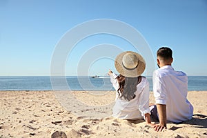 Couple on beach near sea, back view. Honeymoon trip