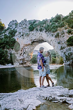 Couple on the beach by the river in the Ardeche France Pont d Arc, Ardeche France,view of Narural arch in Vallon Pont D