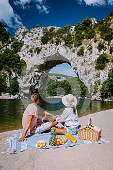 Couple on the beach by the river in the Ardeche France Pont d Arc, Ardeche France,view of Narural arch in Vallon Pont D
