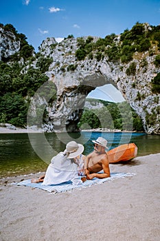 Couple on the beach by the river in the Ardeche France Pont d Arc, Ardeche France,view of Narural arch in Vallon Pont D