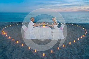 Couple at beach romantic dinner with candles heart