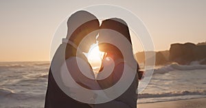 Couple at the beach, sunset and silhouette with people in relationship, forehead touch or hug by the ocean. Travel, love