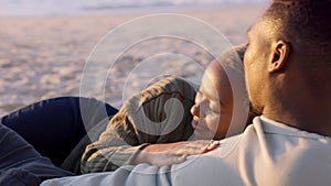 Couple, beach and sunset with a smile, love and hug together while relax on the sand together in summer. African