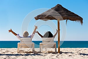 Couple on beach vacation with sunshade photo