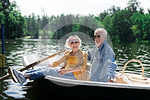 Couple of beaming elderly man and woman feeling satisfied after river trip